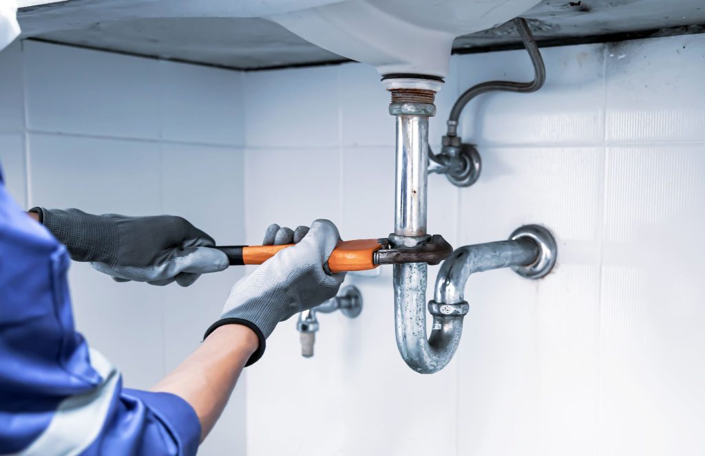Plumber repairing sink pipe