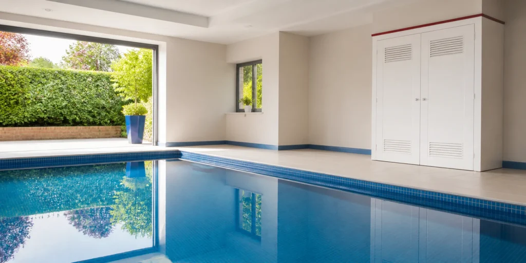 Clean indoor swimming pool with a tidy heating service cupboard